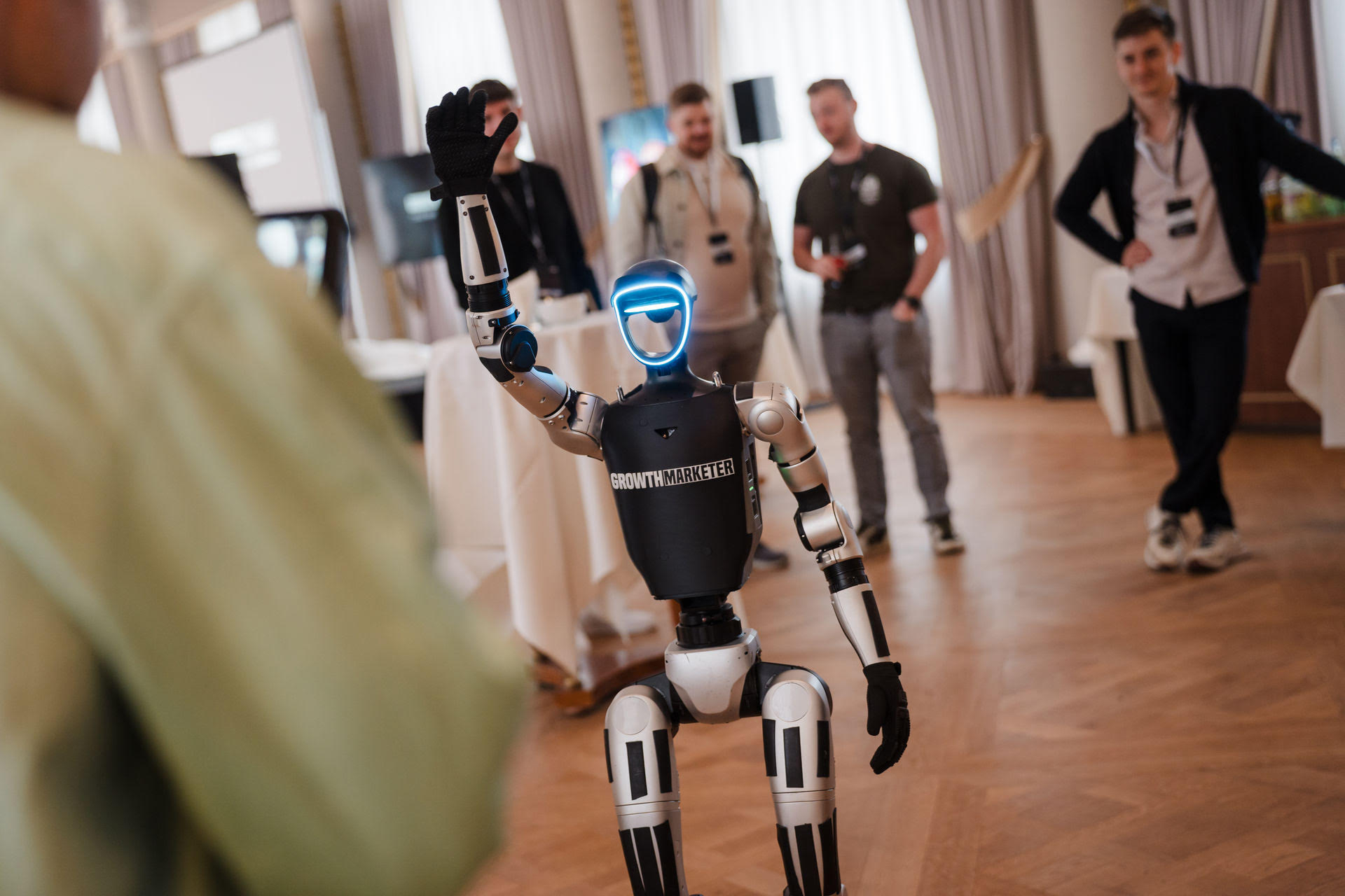 Humanoider Roboter winkt bei einer Event-Inszenierung für den Growth Marketer Summit 2026