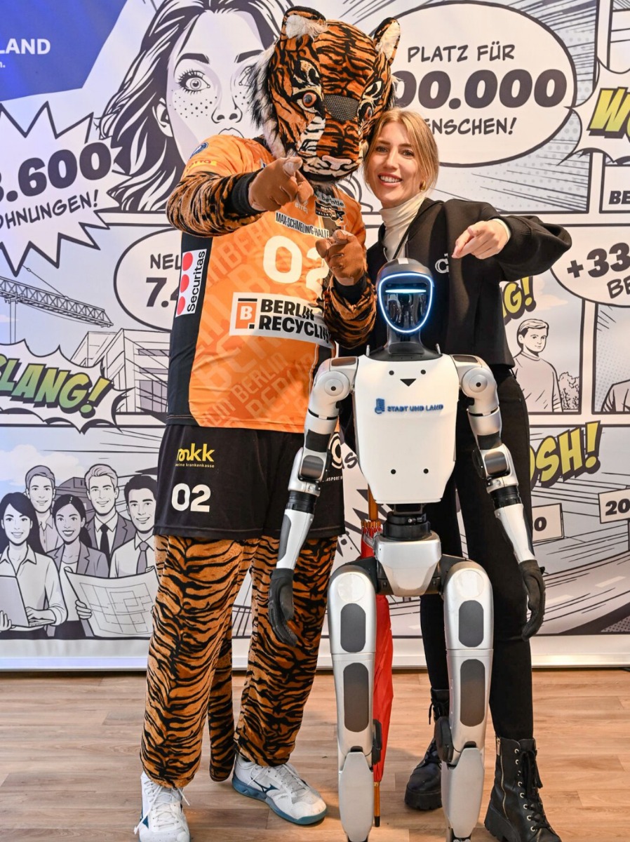 Tiger-Maskottchen mit dem Unitree G1 vor der STADT UND LAND Fotowand