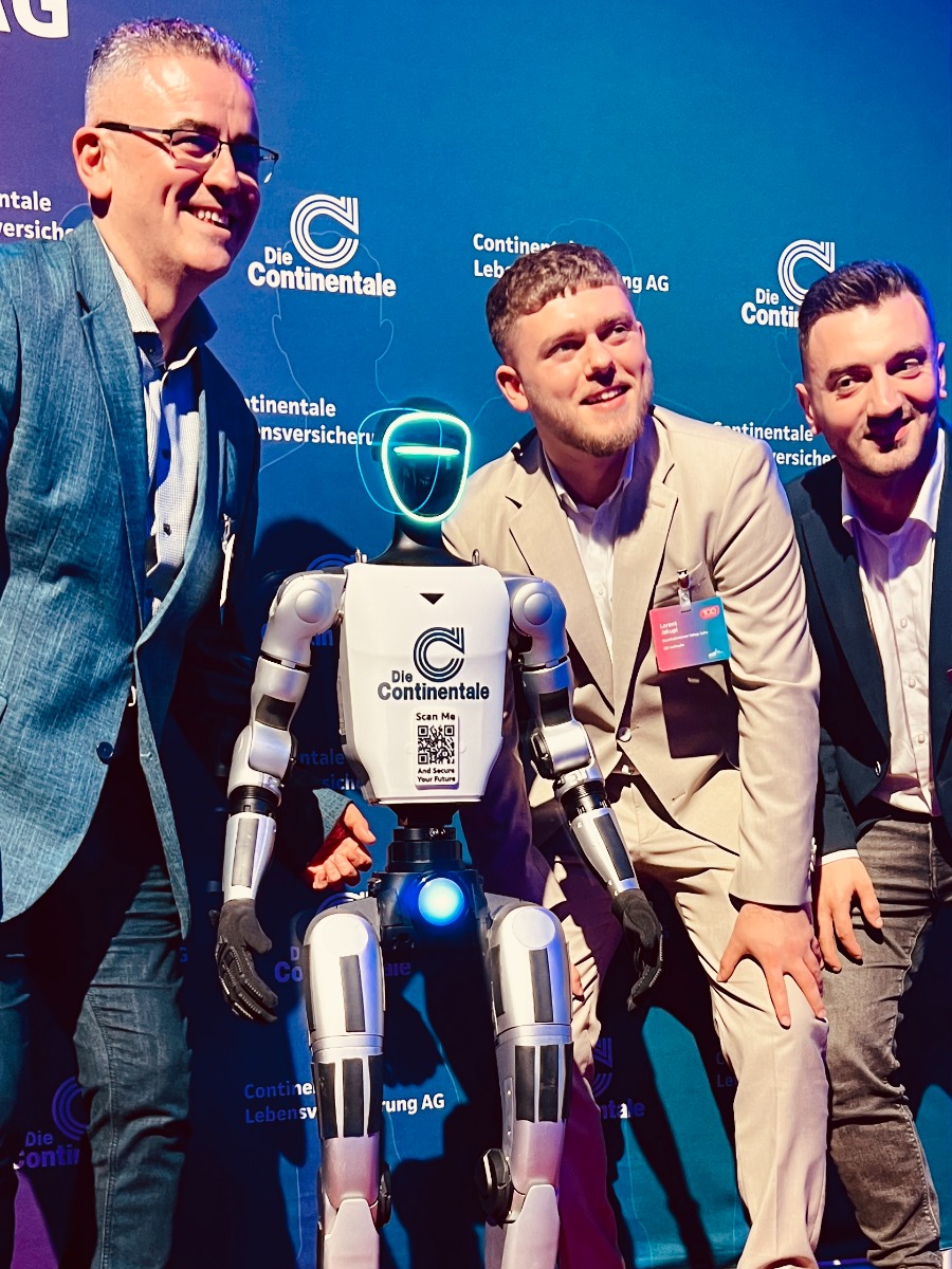 Besucher fotografieren sich mit humanoidem Roboter beim Continentale Agenturforum