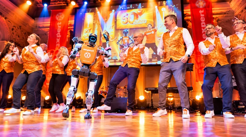 Robotergitarrist zwischen Mitgliedern des expert-Tanzteams während der Bühnenchoreografie