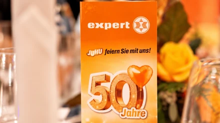 Orangefarbener Tischaufsteller mit expert-Logo und goldener 50 zur Jubiläumsgala
