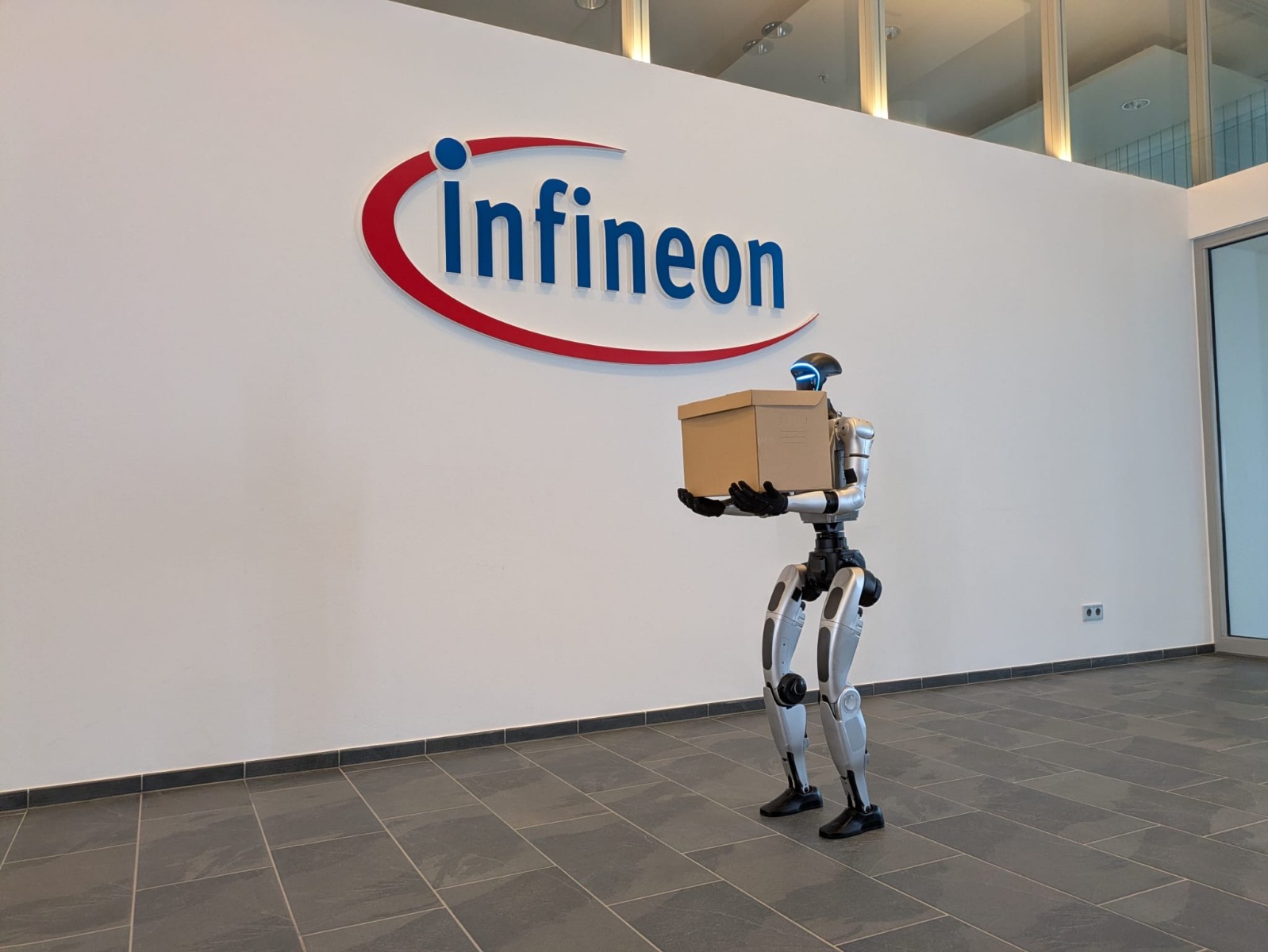 Unitree G1 steht vor dem Infineon-Logo beim Corporate Film-Dreh