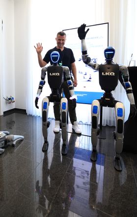 Besucher winkt mit humanoiden Robotern beim LKQ Europe Premium Event 2026