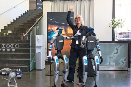 Besucherin posiert mit humanoiden Robotern beim LKQ Europe Premium Event 2026
