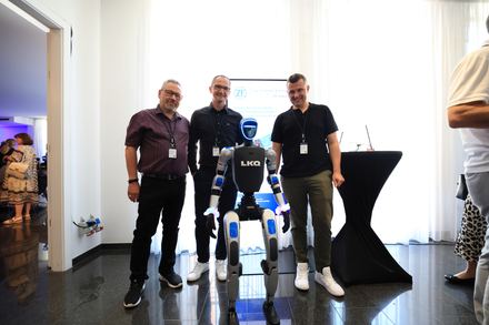 Drei Gäste mit humanoidem Roboter beim LKQ Europe Premium Event 2026