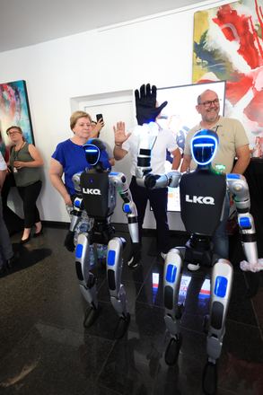 Gast winkt neben humanoiden Robotern beim LKQ Europe Premium Event 2026