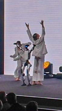 Tänzerinnen und humanoider Roboter während der Bühnenchoreografie