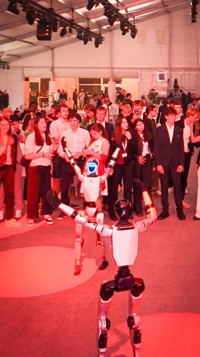 Unitree G1 Roboter mit Besuchergruppe auf rotem Eventboden
