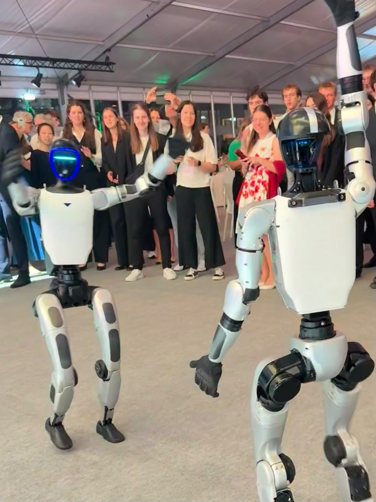 Drei Unitree G1 Roboter bei der Interaktion mit Gästen