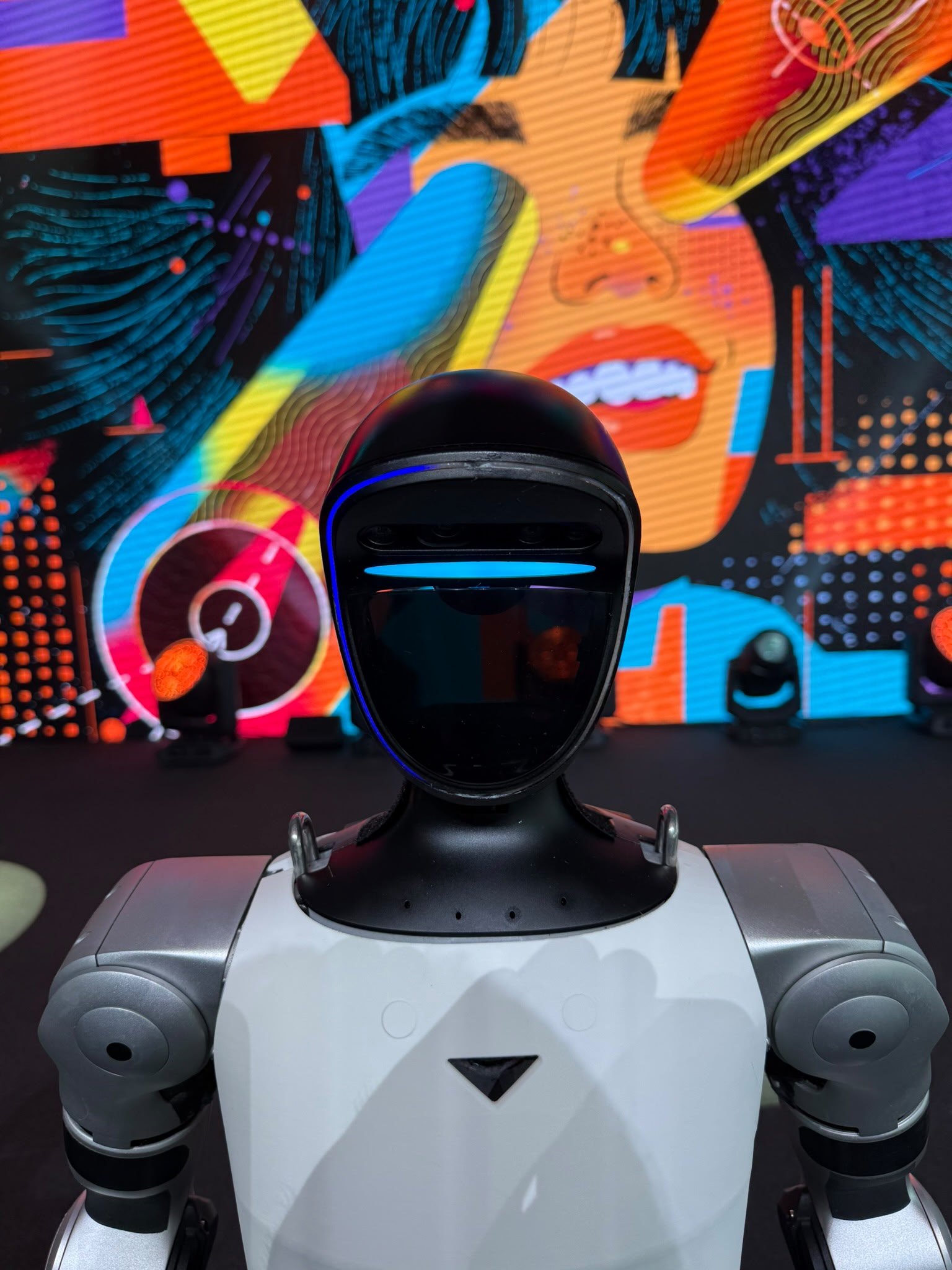 Nahaufnahme eines Unitree G1 Roboters vor farbiger Bühnenkulisse