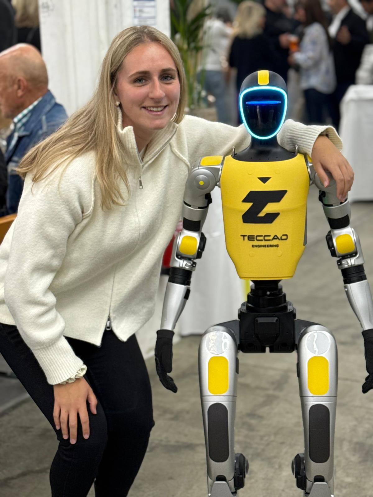 Besucherin steht neben dem humanoiden Roboter Alfons beim TECCAD-Jubiläum