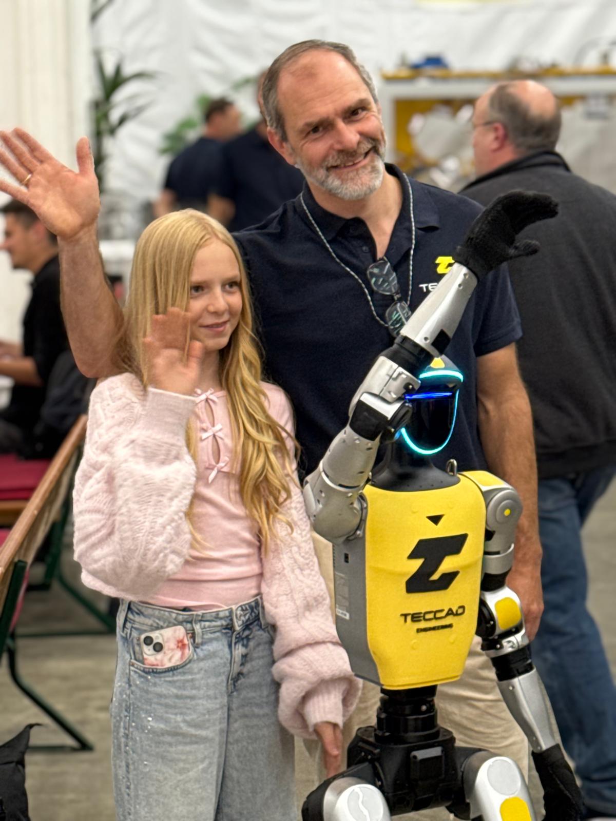 Familie fotografiert sich mit dem humanoiden Roboter Alfons beim TECCAD-Jubiläum