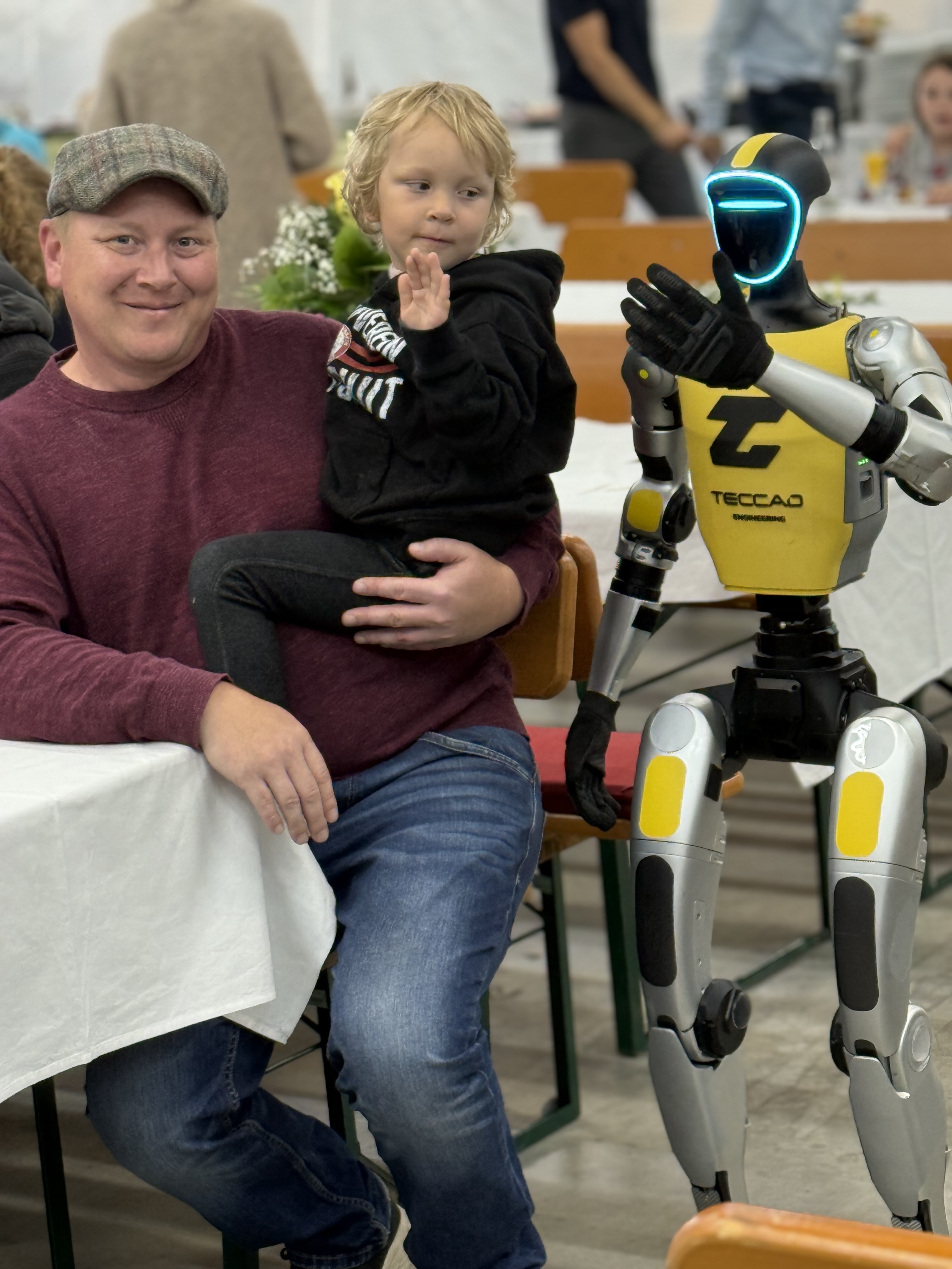 Familie sitzt mit Alfons am Tisch beim TECCAD-Jubiläum