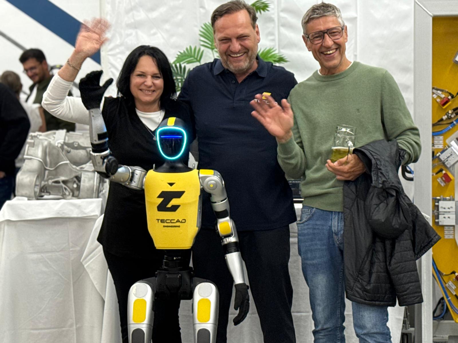 Gäste machen ein Gruppenfoto mit Alfons beim TECCAD-Jubiläum