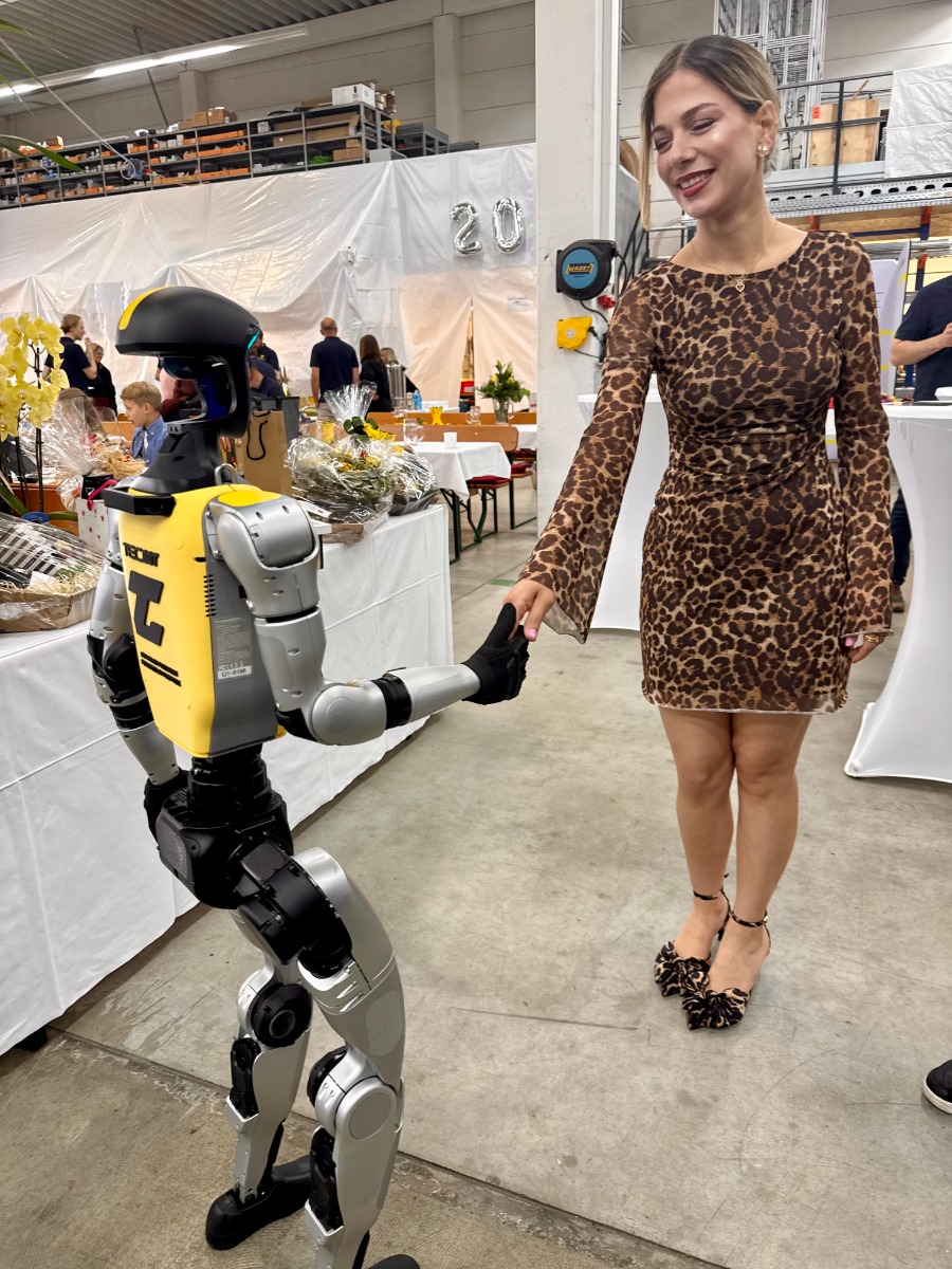 Besucherin interagiert mit dem humanoiden Roboter Alfons bei der TECCAD-Jubiläumsfeier