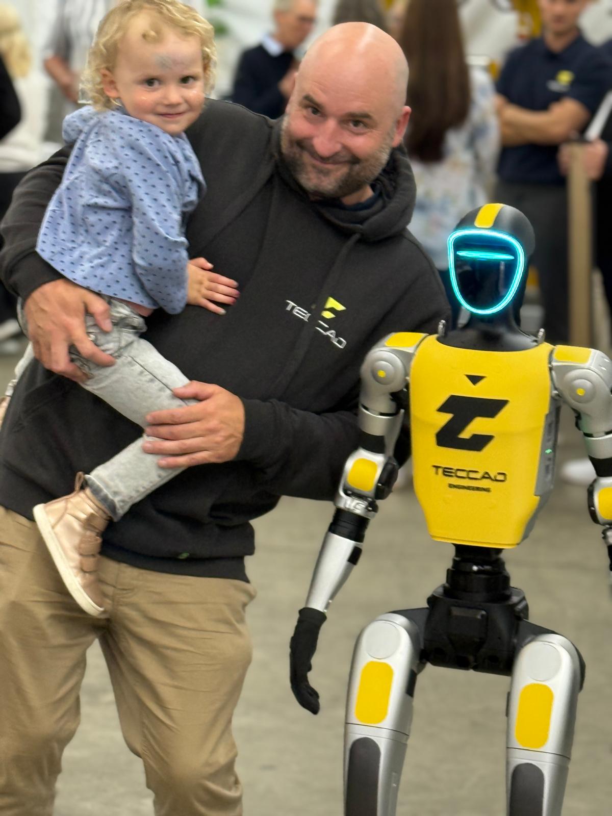 Kind und Erwachsener posieren mit Alfons beim TECCAD-Firmenevent