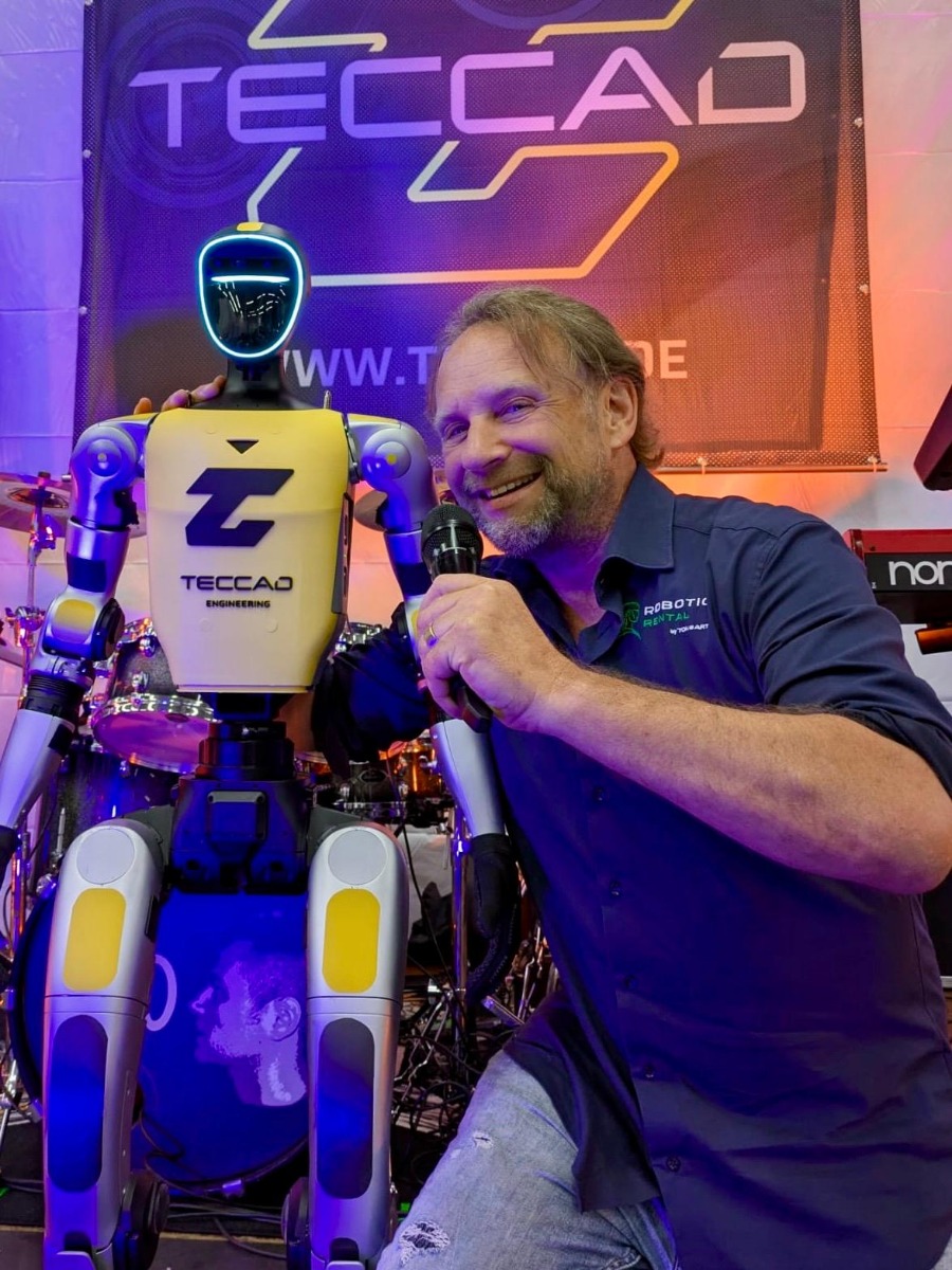 Humanoider Roboter Alfons mit Moderator und Mikrofon auf der Bühne beim 20-jährigen TECCAD Jubiläum in Landshut