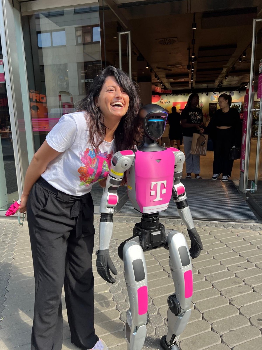 Besucherin mit Telekom-gebrandetem Unitree G1 am Eingang des Telekom Shops Nürnberg
