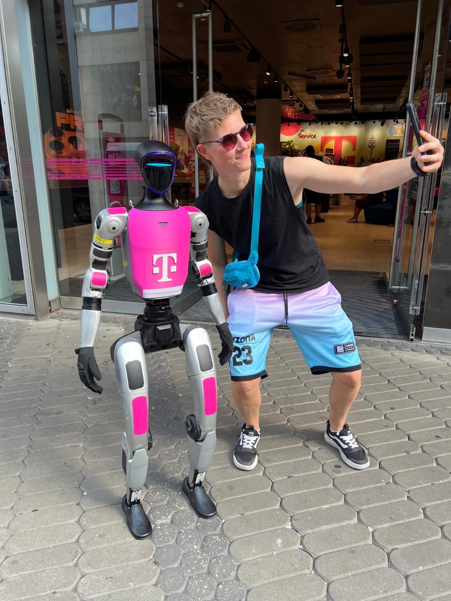 Besucherin macht ein Selfie mit dem Telekom-gebrandeten Roboter Buddy in Nürnberg