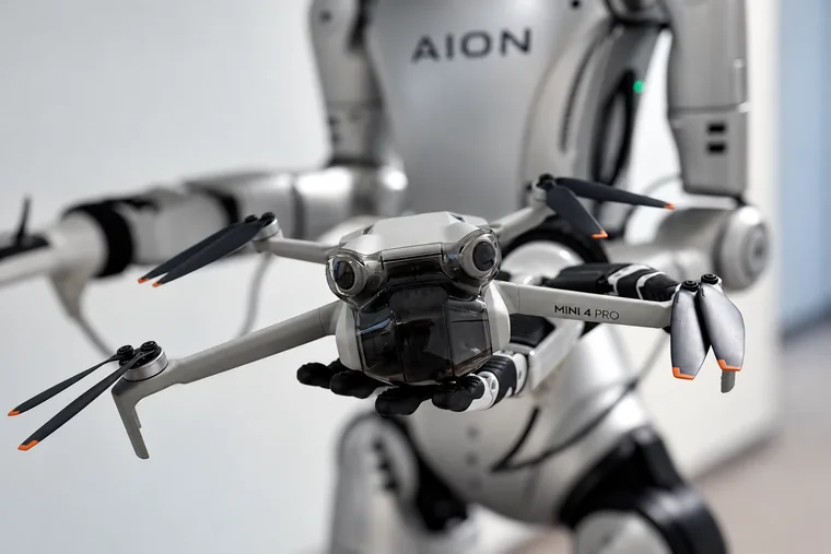 Hellgraue Kameradrohne in Nahaufnahme vor dem AION-Schriftzug am Roboter.